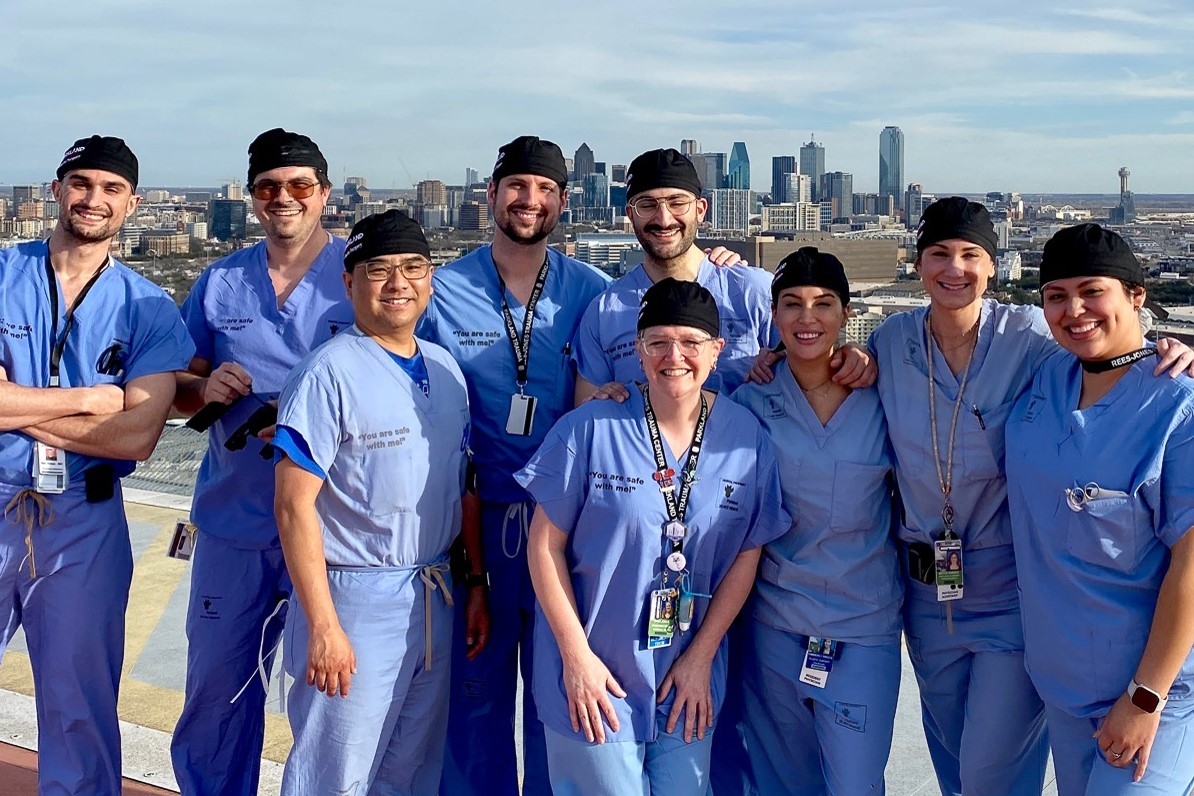 Green light highlights a man wearing glasses and the hose he is holding